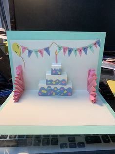 a card with a birthday cake on it sitting on top of a table next to a keyboard