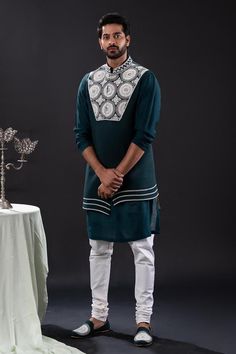 Peacock green sleeveless asymmetric bundi with bloom embroidery using pearls and beads. Paired with long sleeves plain kurta and matching churidar.
Components: 3
Pattern: Embroidered
Type Of Work: Pearl Bloom
Neckline: Band Collar
Sleeve Type: Bundi: Sleeveless, Kurta: Long
Fabric: Mal Cotton, Moss Crepe, Cotton Lycra
Color: Green
Other Details: 
Approx weight: 2kgs
Poly lining
Occasion: Mehendi and Puja, Sangeet - Aza Fashions Festive Green Set With Embroidered Sleeves, Festive Green Sets With Embroidered Sleeves, Bollywood-style Fitted Kurta With Embroidered Sleeves, Traditional Sleeveless Kurta For Reception, Sleeveless Kurta For Eid Reception, Designer Green Kurta With Embroidered Sleeves, Designer Sleeveless Bandhgala With Resham Embroidery, Green Nehru Jacket With Zari Work For Reception, Traditional Sleeveless Bandhgala With Resham Embroidery