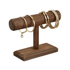 a wooden stand with three bracelets and two rings hanging from the end of it