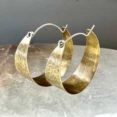 These sweet, wide brass hoops make great "every day" earrings. Hammered and oxidized, sterling ear wire fits into hole in back of hoop to close. Small - around 3/4" diameter Medium - 1 1/2" diameter Large - a little over 2" diameter Cadmium-free Brass Small Hoop Jewelry, Artisan Oxidized Finish Earrings For Everyday, Cadmium-free Hoop Brass Jewelry, Cadmium-free Brass Hoop Jewelry, Small Hammered Metal Hoop Earrings, Artisan Oxidized Hoop Earrings, Oxidized Finish Hoop Earrings As Gift, Oxidized Round Hoop Earrings As Gift, Artisan Hoop Earrings With Oxidized Finish