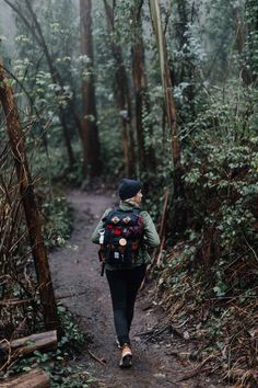 a person walking down a trail in the woods