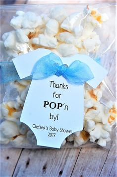 a baby shower popcorn bag with a blue bow on it's head and the words thanks for pop n by