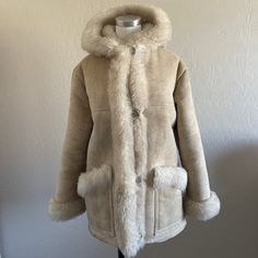 Elevate your winter wardrobe with our exquisite Penny Lane Coat, a perfect fusion of Boho style and vintage charm. Crafted with luxurious shearling and wool materials, this hooded suede coat exudes warmth and sophistication. Inspired by the iconic fashion of the 90s and early 2000s, its Afghan coat design and retro beige hue offer a nostalgic appeal. Whether you're channeling your inner hippie or seeking a statement piece for chilly days, our Penny Lane Jacket delivers both style and comfort. Em Winter White Sheepskin Outerwear With Faux Fur Lining, Winter White Sheepskin Outerwear With Faux Fur Trim, Winter White Sheepskin Outerwear, Winter White Sheepskin Outerwear For Fall, Winter White Sheepskin Outerwear For Winter, Winter White Sheepskin Fur Coat For Fall, Hooded Winter White Outerwear With Faux Fur Lining, Cream Sheepskin Outerwear For Fall, Fall Sheepskin Outerwear With Detachable Hood