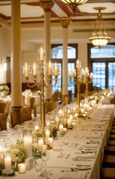 a long table is set with candles and place settings