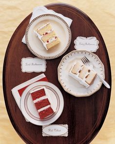 two slices of red velvet cake on plates with place cards and napkins next to them