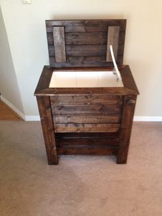 an old wooden box with a white toilet in it's seat is sitting on the floor