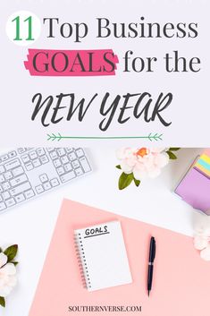 the top business goals for the new year with flowers, keyboard and notepad on it