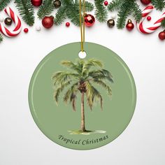 a christmas ornament with a palm tree and candy canes hanging from it