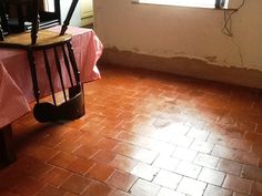 an empty room with a table, chair and window on the floor in front of it