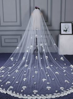 a wedding veil with white flowers on it