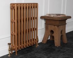 a wooden radiator next to a small table with a book on it,