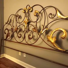 a metal headboard with gold leaf designs on it