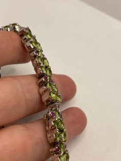 This Peridot and Ruby bracelet is very lively and bright. The stones are deep colors and well matched. The sterling silver is plated with rhodium to protect the bracelet from tarnish and give the appearance of white gold. My jeweler can shorten this for a $20 fee 7.5 inches All jewelry is shipped in a nice gift box. Check out our over a THOUSAND great reviews!!! Engraving is $4 per letter and is not always perfect depending on the piece. It can take a few days if the jeweler is busy. This is pay Sterling Silver Multi-stone Bracelets, Sterling Silver Bracelet With Gemstone, Sterling Silver Fine Jewelry Bracelets With Stones, Luxury Multi-stone Peridot Jewelry, Luxury Peridot Multi-stone Jewelry, Luxury Hallmarked Peridot Jewelry, Sterling Silver Gemstone Tennis Bracelet, Luxury Sterling Silver Bracelets With Stones, Sterling Silver Multi-stone Round Bracelet