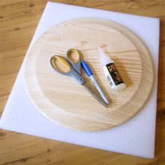 scissors and glue sitting on top of a cutting board