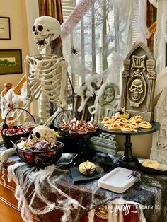 a table topped with halloween treats and skeletons