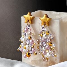 These Christmas Tree earrings are all blinged out with pretty gold, blush, and silver rhinestones and pearls.  Pair with a winter white sweater or dress for an elegant yet fun holiday look. Makes a great gift for moms, teachers, office gift exchanges, or anyone who loves Christmas and sparkle! 🎄Just under 2.5" long 🎄1.5" at widest point 🎄Star is .5" across 🎄Stainless steel ear posts 🎄Made from lightweight resin 🎄Wrapped and ready for gifting! White Winter Party Jewelry, White Jewelry For Holiday Party, White Holiday Party Jewelry, Gold Jewelry For Winter Party, White Embellished Earrings For Party, Christmas Party Jewelry, Fancy Pens, Tree Earrings, Christmas Tree Earrings