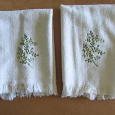 two white towels with embroidered flowers on them