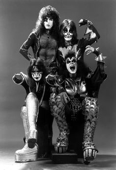 the kiss band posing for a photo in their costumes, with one man sitting on top of