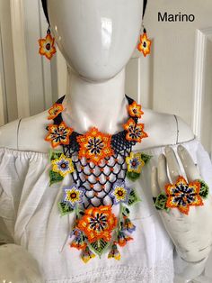 a white mannequin with an orange and green necklace on it