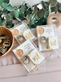 three pieces of jewelry sitting on top of a table next to a basket filled with coins