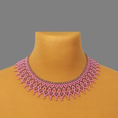 a pink necklace is displayed on a mannequin's neckline in front of a yellow shirt