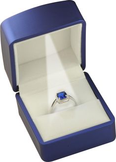 an open ring box with a blue stone in it's center and light shining through the opening