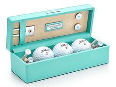 four golf balls in a blue case on a white background