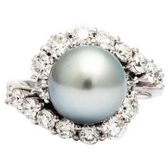 A Silver gray Tahitian pearl and white diamonds ring from the collection "Purity Di Perle" from FERRUCCI ., in a modern swirl design to compliment the delicate unique class of a sophisticated woman,Cherished as symbols of purity and perfection, elegance and affluence, Made in Italy Entirely made in 18k white gold, Size 6.75 Diamond total carat weight of 1.72 carat weight Silver Gray Tahitian Pearl 10.1 carat weight Diamond Pearl Ring, Tahitian Pearl Ring, Pearl Cocktail Ring, Pearl Wedding Ring, Fine Pearl Jewelry, Victorian Engagement Rings, Tahitian Black Pearls, Pearl And Diamond Ring, Vintage Style Rings