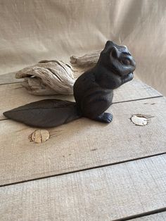 a statue of a sea lion sitting on top of a piece of wood next to a driftwood branch