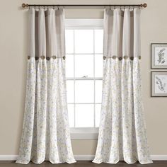 the curtains in this room are white and beige with yellow flowers on them, while the window