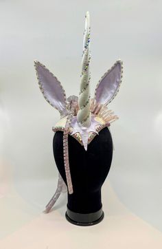 Handmade one-of-a-kind headpiece inspired by the 1982 anime film, The Last Unicorn. Hand-painted lavender leather star and ears, horn with iridescent sparkle and Swarovski crystals, beaded trim and rhinestone chain trim, white brocade fabric. The abundant spiral "hair" is hand-made silicone art from the Carol Motty studio. Carol Motty was a notable silicone artist popular in the 80's and 90's. It's a special addition! This is a very comfortable and fun piece to wear. It's secured to the head with an adjustable elastic strap. Unicorn Masquerade Mask, Unicorn Hair Accessories, Fantasy Costume Accessories With Tall Crown For Cosplay, Fantasy Tall Crown Costume Accessories For Cosplay, Pink Costume Accessories For Cosplay Party, Pink Costume Accessories For Cosplay Party Events, Purple Themed Party Costume Accessories, Themed Costume Hats For Cosplay Events, Whimsical Purple Costume Hats For Halloween