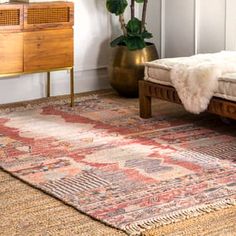 a bed sitting on top of a wooden floor next to a dresser and rug in a room