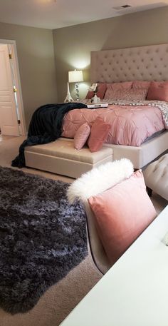 a bedroom with a bed, chair and ottomans in the middle of the room