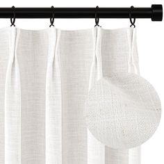 a white curtain hanging on a black rod with a round piece of fabric in front of it