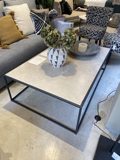 a living room with couches, chairs and coffee table in front of the couch