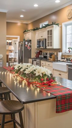 a kitchen decorated for christmas with lights on the counter top and holiday decorations hanging from the ceiling