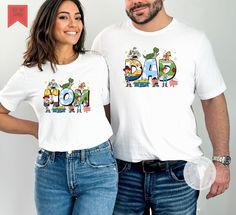 Super cute Mom or Dad Toy Story  tee shirt.    🔸This listing is for one item, please select each shirt you would like with their personalization separately  🔶 The design is a DTG  and printed on a Bella Canvas white unsex tee shirt. Please see second picture for measurements. Playful Father's Day T-shirt For Family, Playful Cotton Family T-shirt, Family Crew Neck T-shirt With Character Print, Crew Neck T-shirt With Character Print For Family, Fun T-shirt With Character Print For Gift, Father's Day Cartoon Print Crew Neck T-shirt, Family Cotton T-shirt With Cartoon Print, Cute Cartoon Print T-shirt For Mother's Day, Family Cartoon Print Cotton T-shirt