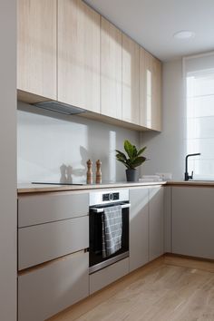 a kitchen with wooden cabinets and white walls, an oven and dishwasher on the counter