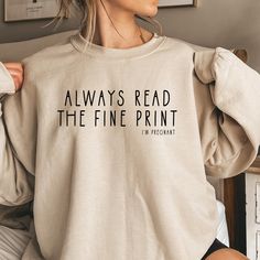 a woman wearing a sweatshirt that says, always read the fine print