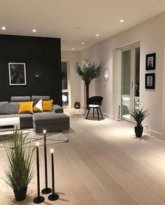 a living room filled with lots of furniture next to a tall black and white wall