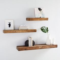 two wooden shelves with books and vases on them