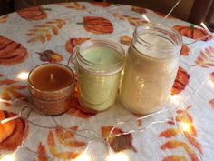 three jars filled with candles sitting on top of a table