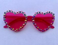 "Bedazzled \"Girls Run the World\" pink heart sunglasses perfect for brunch, a party, or a festival. All sunglasses are decorated with love and care by hand." Trendy Pink Sunglasses For Festivals, Pink Tinted Sunglasses For Festival, Personalized Pink Sunglasses For Party, Bedazzled Sunglasses, Festival Glasses, Pink Heart Sunglasses, Beaded Sunglasses, Girls Run The World, Heart Glasses