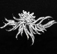 a brooch that is on top of a black surface and has many small crystals in it