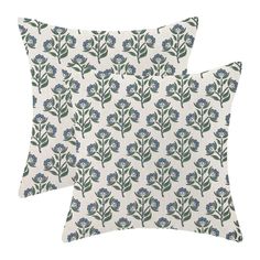 two pillows with blue flowers on them, one is white and the other has green leaves