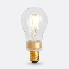 a light bulb that is on top of a white surface with gold trimmings