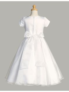 Gorgeous First Communion dress by Lito for your sweet girl. Short sleeve tea length style in white with round neckline satin bodice and crystal organza skirt. Features zipper closure and bow tie at the back. Whether your daughter is attending a communion, wedding, or other special event, this dress is the perfect choice for a truly unforgettable look. And if you have a younger daughter who also needs a dress, be sure to check out our original Lito Girls White Short Sleeve Crystal Organza Communi Short Dresses For Girls, White Short Dresses, Girls First Communion Dresses, Communion Wedding, Girls Communion Dresses, Baptism Gown, Off Shoulder Gown, First Communion Dress, Organza Skirt