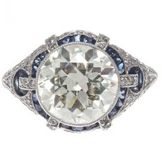 an antique diamond and blue sapphire ring with diamonds on the sides, set in 18k white gold