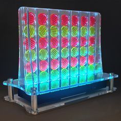 a display case with balls in it on a black background and some colored lights behind it