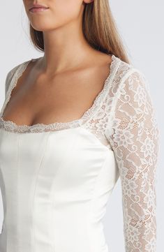 Sheer lace sleeves enhance the romance of a corset-inspired top fashioned with a smooth satin bodice and structured boning. Back zip; keyhole with button-and-loop closure Square neck Long sleeves Lined, with structured boning 100% polyester with 84% polyamide, 16% elastane and 90% polyamide, 10% elastane contrasts Dry clean Imported Feminine Delicate Lace Fitted Corset, Elegant Corset With Lace Trim And Sweetheart Neckline, Elegant Corset With Sweetheart Neckline And Lace Trim, Elegant Formal Corset With Lace Trim, Fitted Lace Corset For Wedding Night, Elegant Lace Corset For Wedding Night, Elegant Lace Wedding Night Corset, Elegant Lace Wedding Corset, Elegant Corset With Lace Bodice